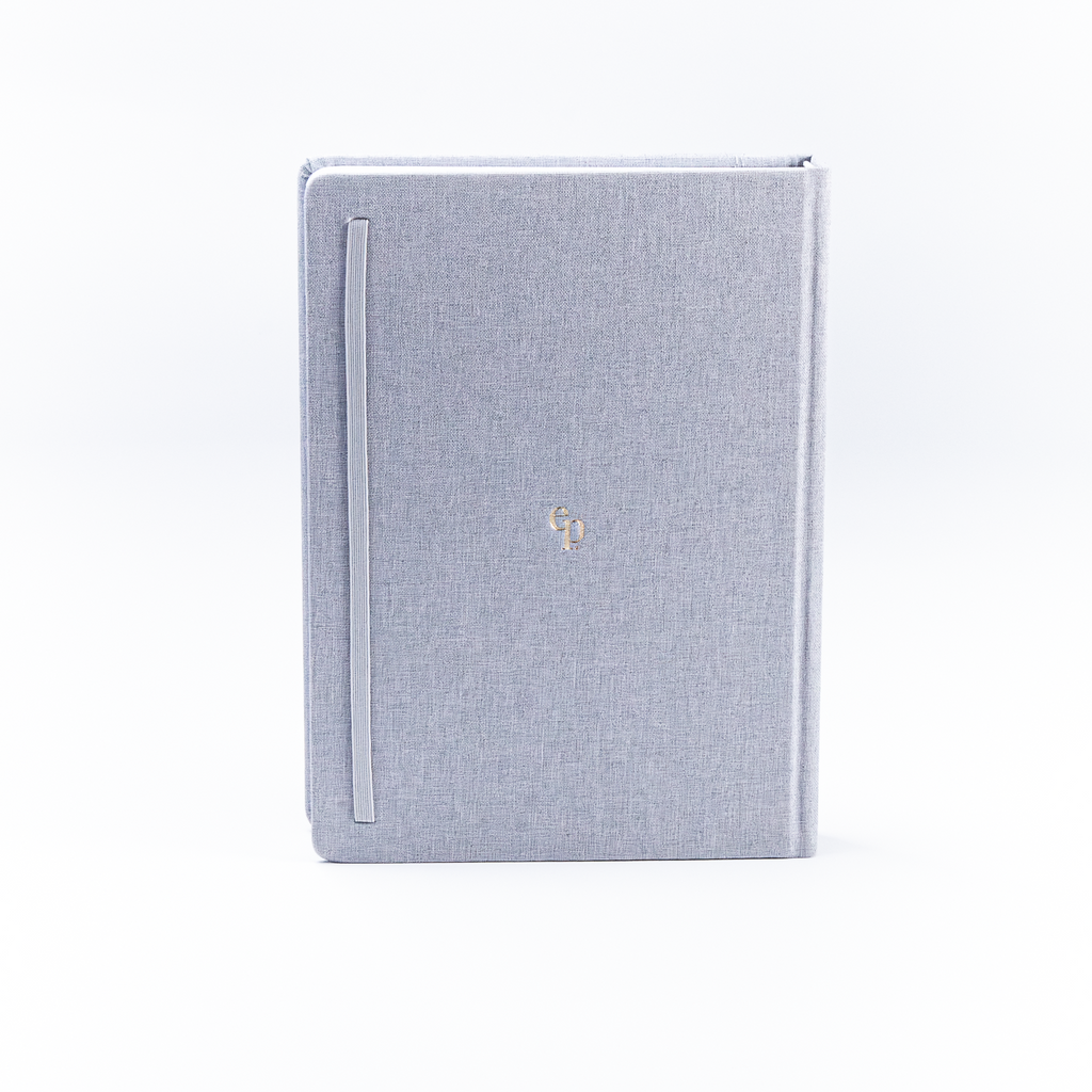 Light blue fabric-bound book with a gold emblem on a white background